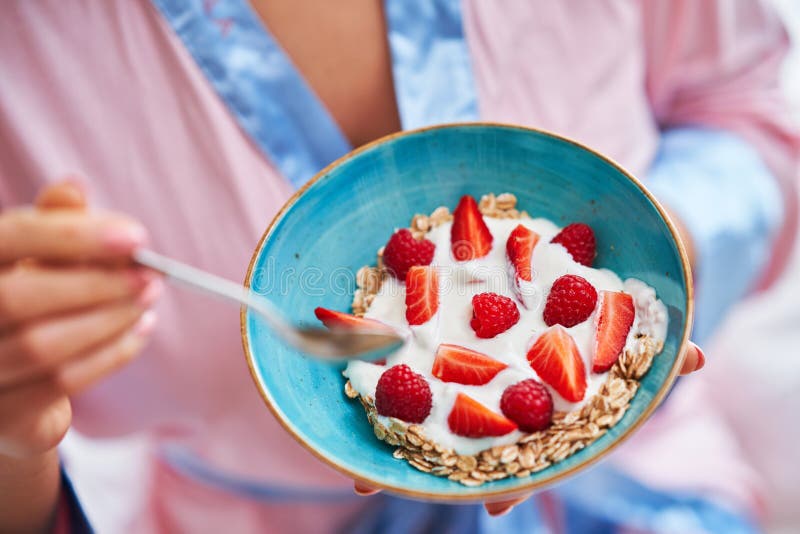 Portrait of young woman in underwear eating cereals