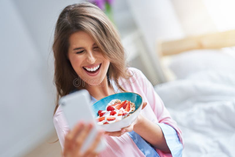 Portrait of young woman in underwear eating cereals