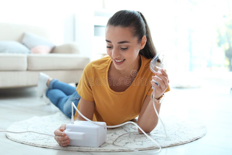 Young woman using asthma machine at home royalty free stock photos Young woman using asthma machine at home royalty free stock photos