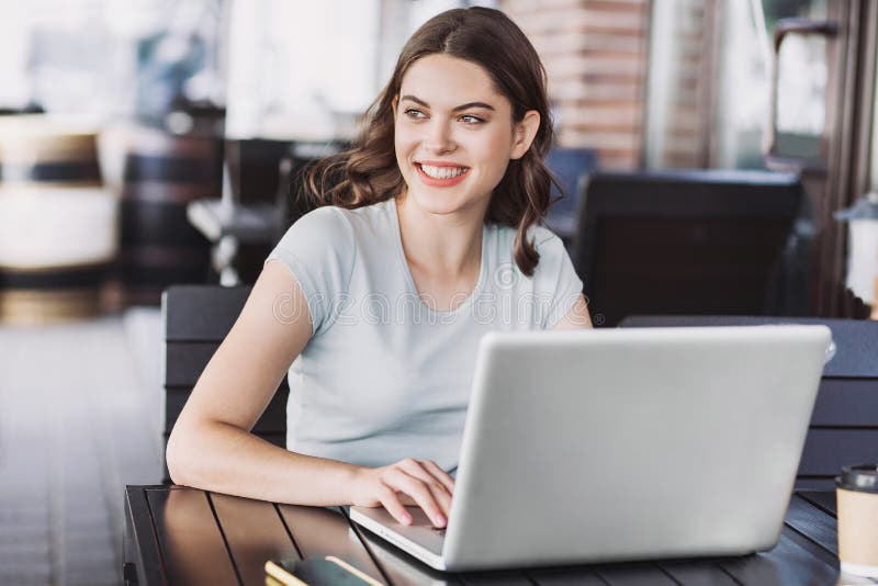 Young woman using laptop indoors. Beautiful happy girl working on computer in a cafe. stock photography Young woman using laptop indoors. Beautiful happy girl working on computer in a cafe. stock photography