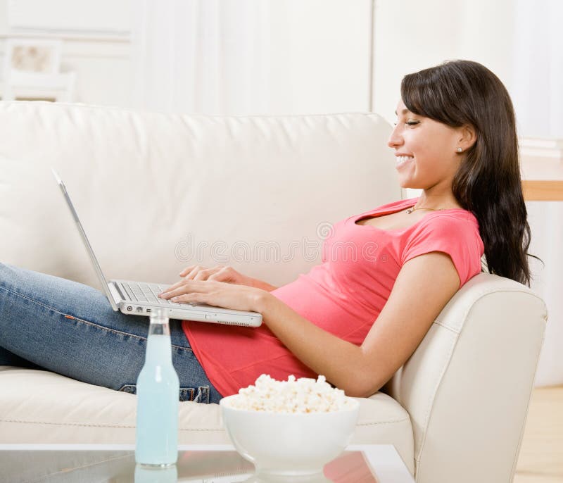 Young woman using laptop on sofa at home