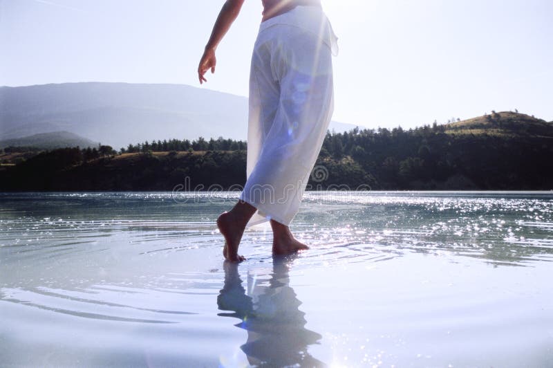 Young woman wading in lake.