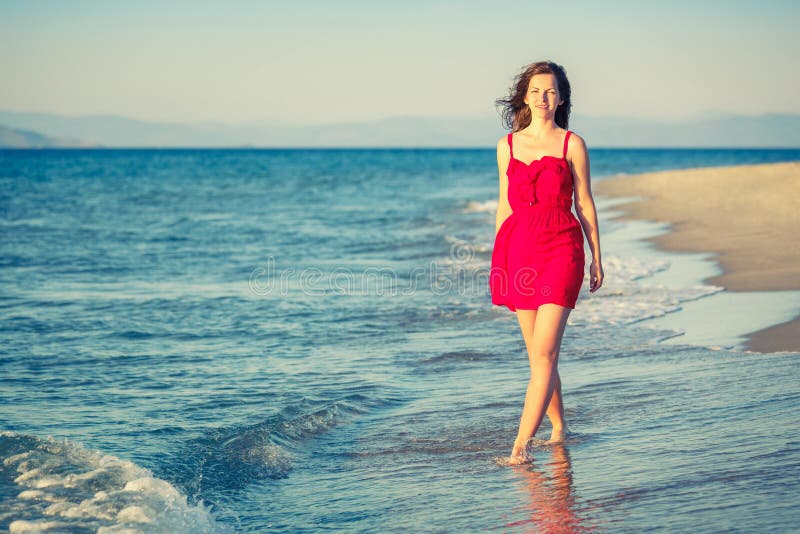 Young Woman Walking on the Beach Stock Image - Image of dress, smiling ...