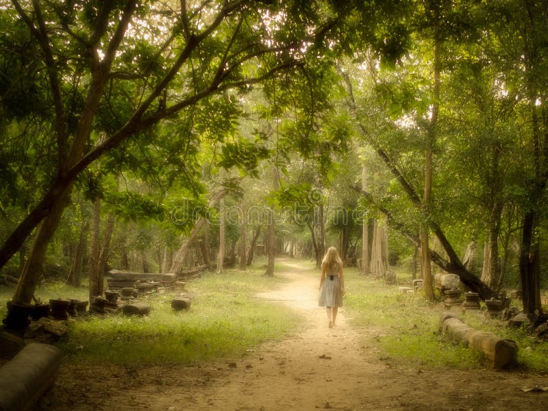 Young Woman Walking on Mysterious Path into Enchanted Forest