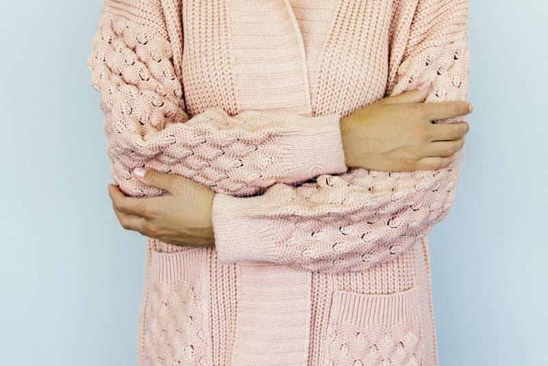 Young woman in a warm knitted sweater folded hands on the belt royalty free stock image Young woman in a warm knitted sweater folded hands on the belt royalty free stock image