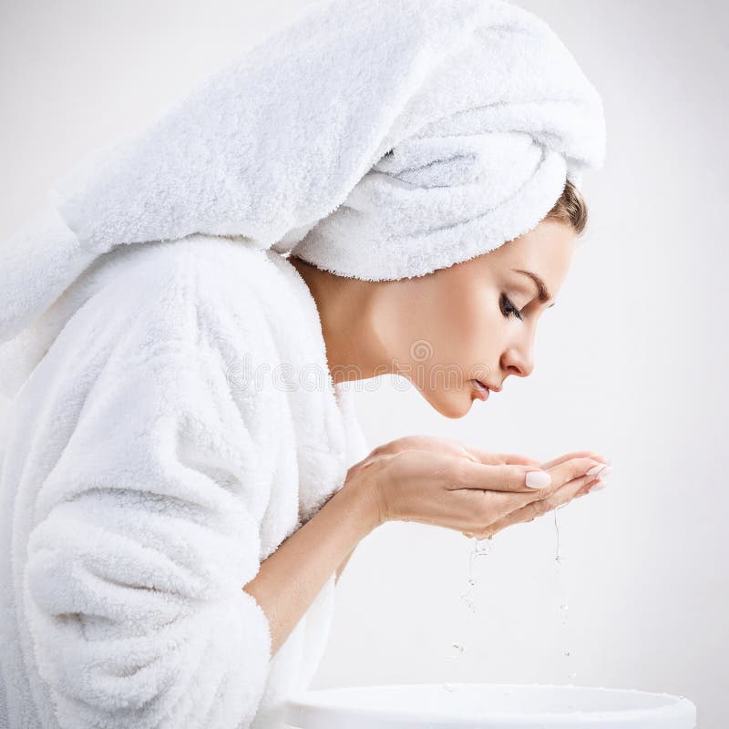 Young woman washing face with clean water. Caucasian, bathtub.