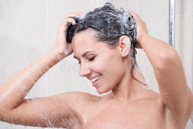 Young woman washing head by shampoo royalty free stock image
