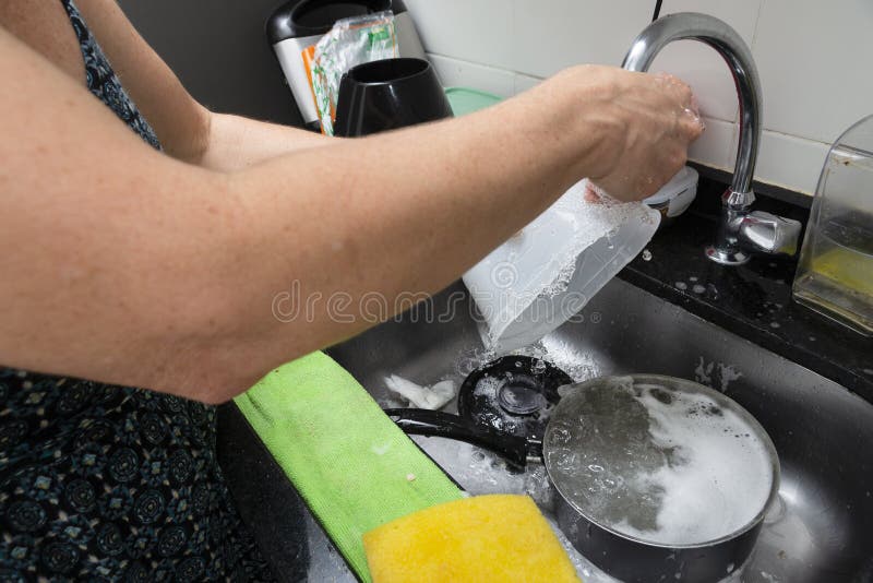 Young Woman Washing Pan and Utensils in the Kitchen. Hygiene in the Kitchen Stock Photo Image