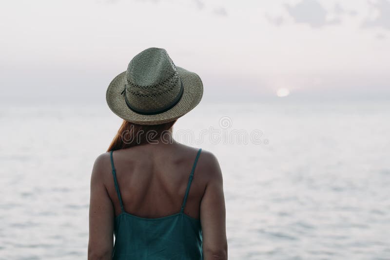 Silhouette Of Woman Standing On Ocean Beach And Looking Away During