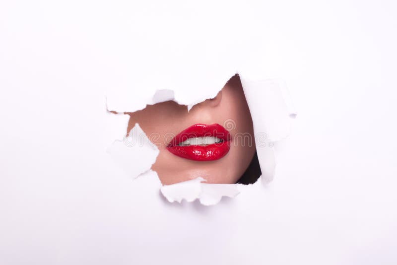 Young woman wearing beautiful lipstick, view through hole in color paper. stock photography Young woman wearing beautiful lipstick, view through hole in color paper. stock photography