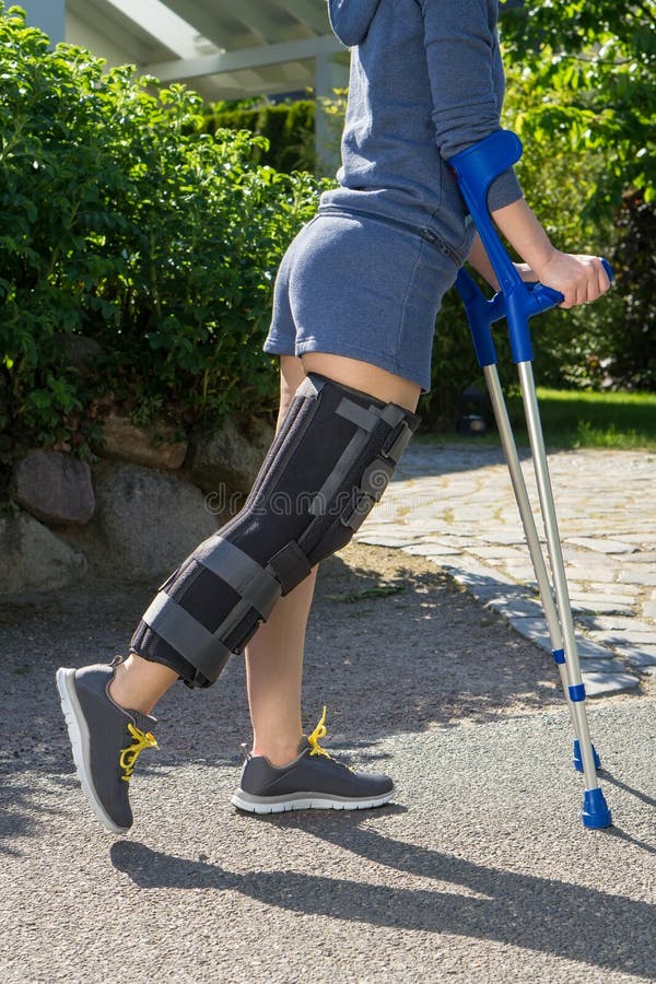 Young woman wearing a leg brace, side view stock photos Young woman wearing a leg brace, side view stock photos