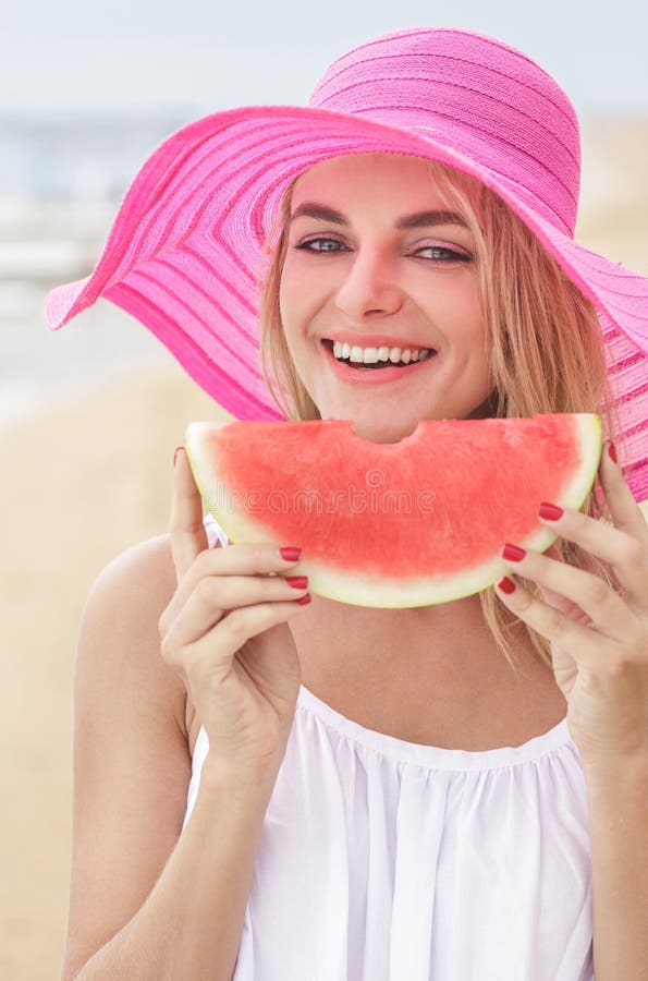Young woman wearing pink sunhat smiling and eating watermelon royalty free stock image Young woman wearing pink sunhat smiling and eating watermelon royalty free stock image