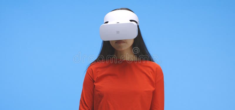 Young woman wearing vr headset and doing hand gestures. Medium shot of young woman wearing vr headset and doing hand gestures against blue background stock photos Young woman wearing vr headset and doing hand gestures. Medium shot of young woman wearing vr headset and doing hand gestures against blue background stock photos