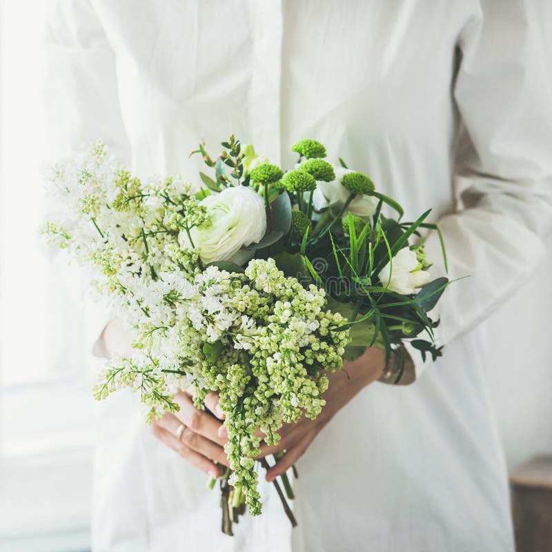 Young woman wearing white clothes holding flowers bouquet, square crop