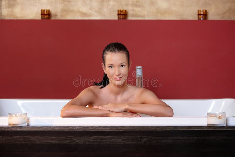 Woman Relaxing In Bathtub Looking At The Camera Stock