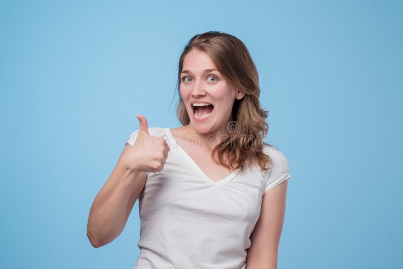 Young woman in white shirt showing thumbs up royalty free stock image Young woman in white shirt showing thumbs up royalty free stock image
