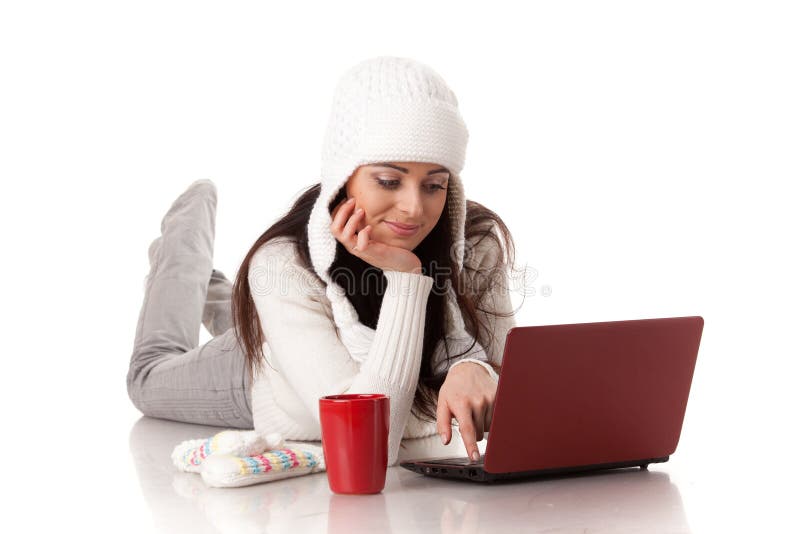 Beautiful young woman in winter clothes with laptop lies on a white background. Winter woolen clothes stock images, royalty-free photos and pictures