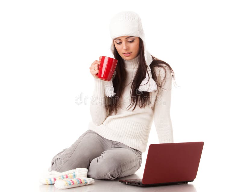 Beautiful young woman in winter clothes with laptop sits on a white background. Winter woolen clothes stock images, royalty-free photos and pictures