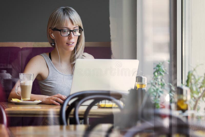 Mujer joven en negocios computadora en cafetería, de en negocios en cualquier lugar o 24  7 