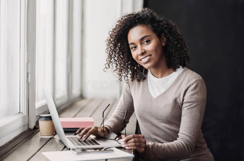 Young woman working in modern business office. Student girl using laptop computer at cafe.