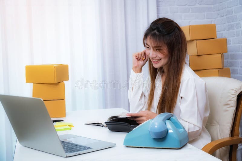 Young Women happy after new order from customer, business owner working at home office packaging on background. online shopping royalty free stock image Young Women happy after new order from customer, business owner working at home office packaging on background. online shopping royalty free stock image