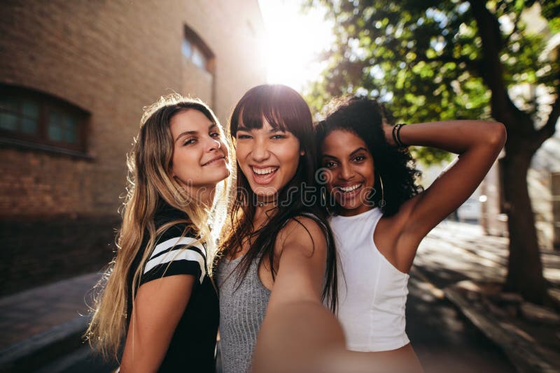 Young women having fun on city street and taking selfie royalty free stock photos Young women having fun on city street and taking selfie royalty free stock photos