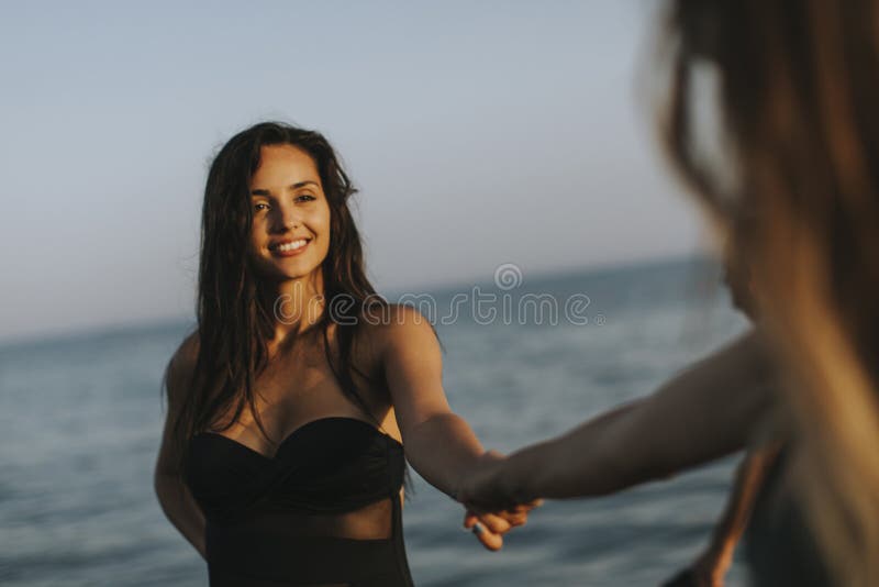 Young women having fun at summer vacations on the beach