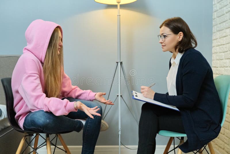 Young women in meeting with female psychologist, girl student telling her problems therapist, mental health of youth. Young women in meeting with female psychologist, girl student telling her problems therapist, mental health of youth