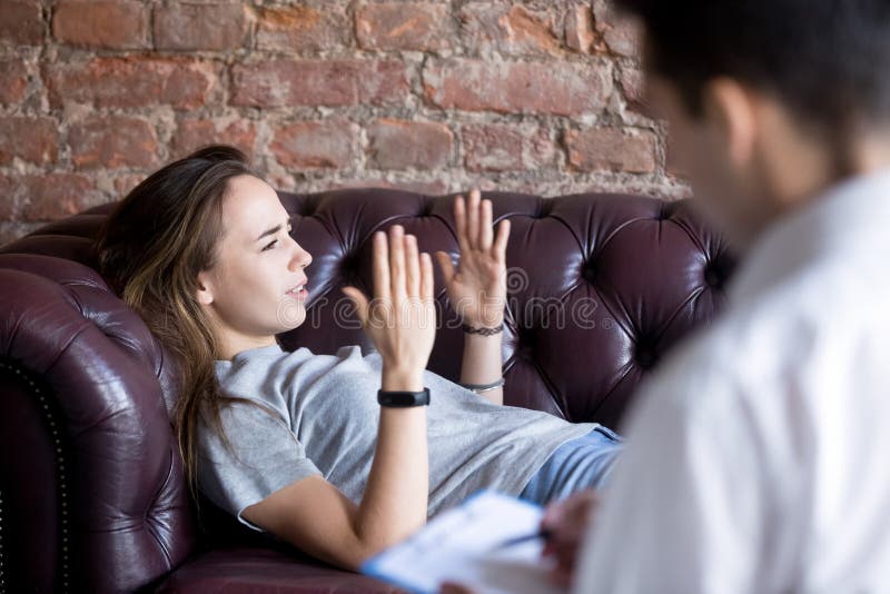 Young woman telling a psychologist counselor about her problems royalty free stock photography