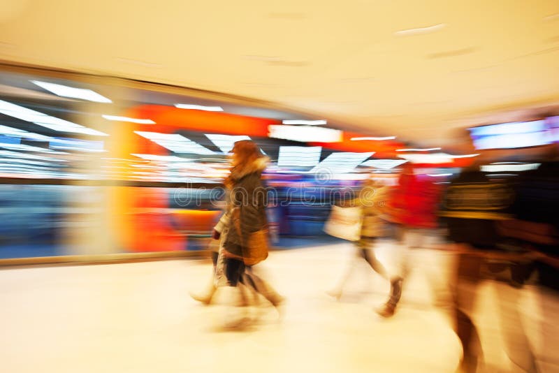 Young women walking past window display in clothes shop