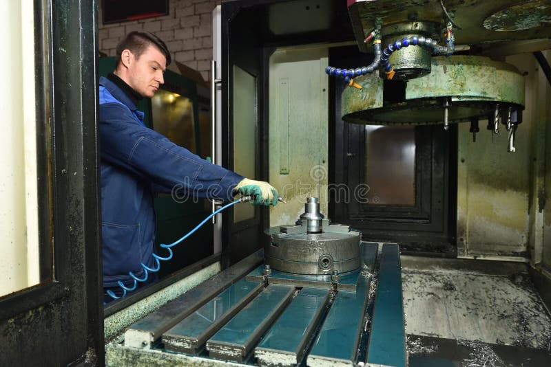 Stariy Oskol Russia - 18. 01. 2018: A young worker blows metal shavings from the chuck spindle with a stream of air from the stock photo