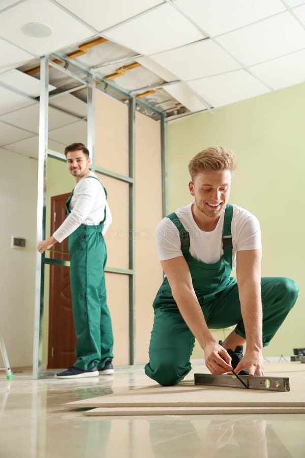 Young Workers Installing Drywall. Home Repair Service Stock Image