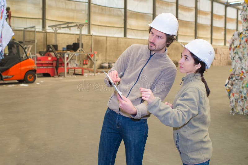 Young workers in junkyard stock image. Image of suit 264392239