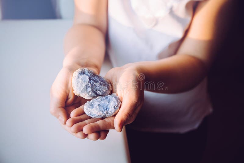 Young 7 year old girl child holding clusters of blue crystals called Celestite. An Indigo Child concept.