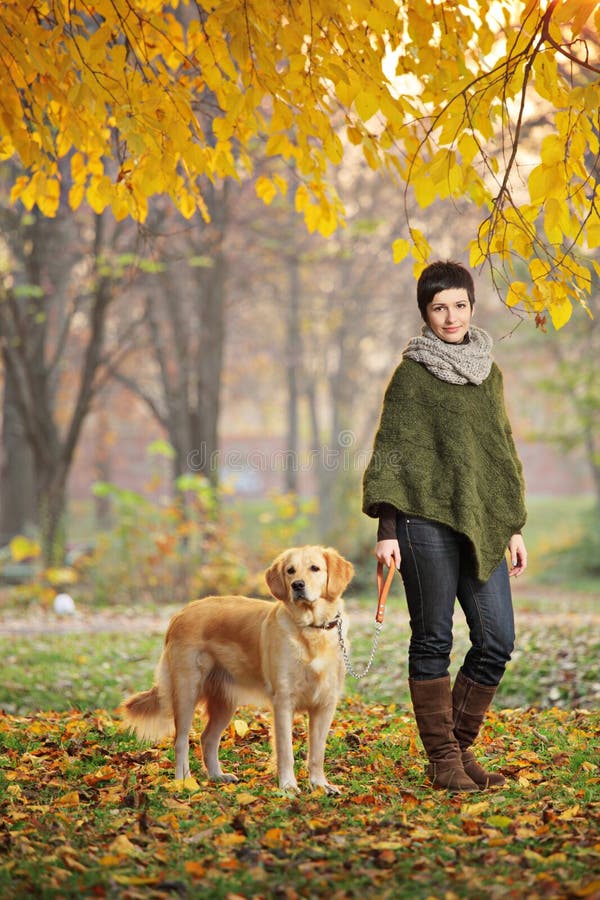 Young girl and her dog walking in autumn