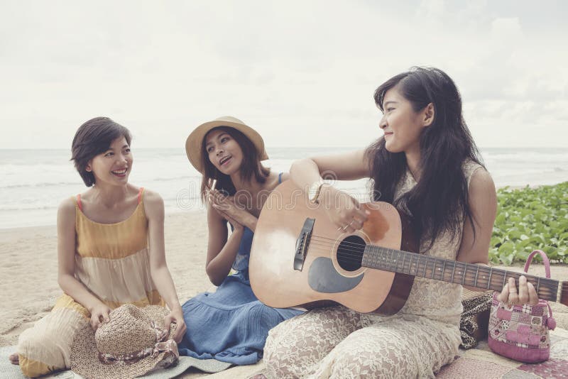 Younger asian woman friend vacation relaxing playing guitar and stock photos Younger asian woman friend vacation relaxing playing guitar and stock photos