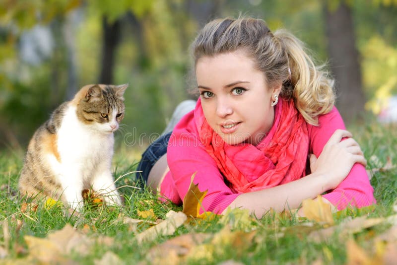 Young girl with cat on natural background