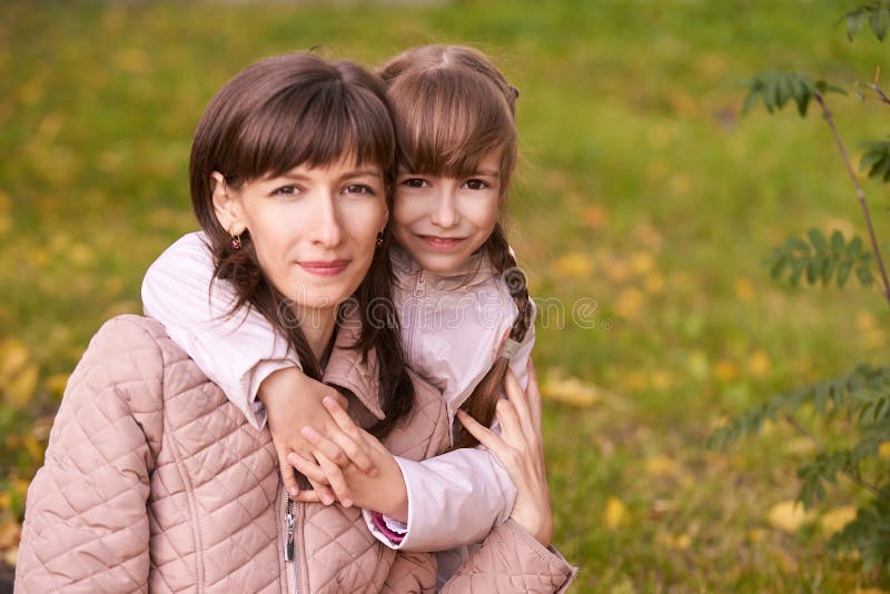Younvrouw met dochter outdoors De achtergrond van de herfst Rode en oranje het bladclose-up van de kleurenKlimop Moeder en Dochte royalty-vrije stock foto's Younvrouw met dochter outdoors De achtergrond van de herfst Rode en oranje het bladclose-up van de kleurenKlimop Moeder en Dochte royalty-vrije stock foto's