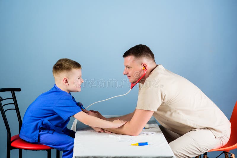 Yrkesm?ssigt samtal Medicin och h?lsa liten pojke med farsalek Framtida karri?r r familj arkivbild Yrkesm?ssigt samtal Medicin och h?lsa liten pojke med farsalek Framtida karri?r r familj arkivbild