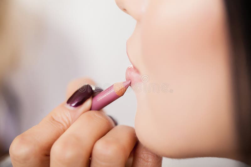 Yrkesmässig makeupkonstnär som applicerar läppstift arkivbilder Yrkesmässig makeupkonstnär som applicerar läppstift arkivbilder