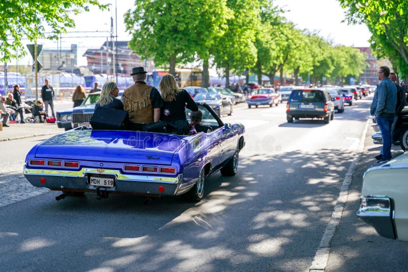 Ystad, Sweden - May 14 2019: Classic cars cruising in the city at Summer Meet . Lots of people standing on the side of the street