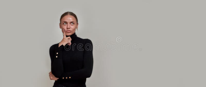Ytlig kaukasisk ung kvinna som bär svart turtleneck-finger nära ansiktet och ser tankfull ut royaltyfri fotografi