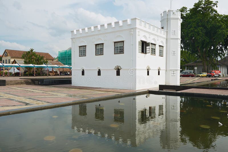Yttersida av den vita historiska byggnaden reflekterade i vattnet av dammet i Kuching, Malaysia arkivbild Yttersida av den vita historiska byggnaden reflekterade i vattnet av dammet i Kuching, Malaysia arkivbild