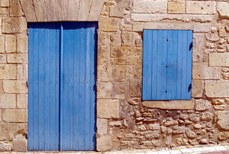 Yttre detalj av ett traditionellt stenhus med det stängda blåa fönstret och dörren arkivfoto Yttre detalj av ett traditionellt stenhus med det stängda blåa fönstret och dörren arkivfoto