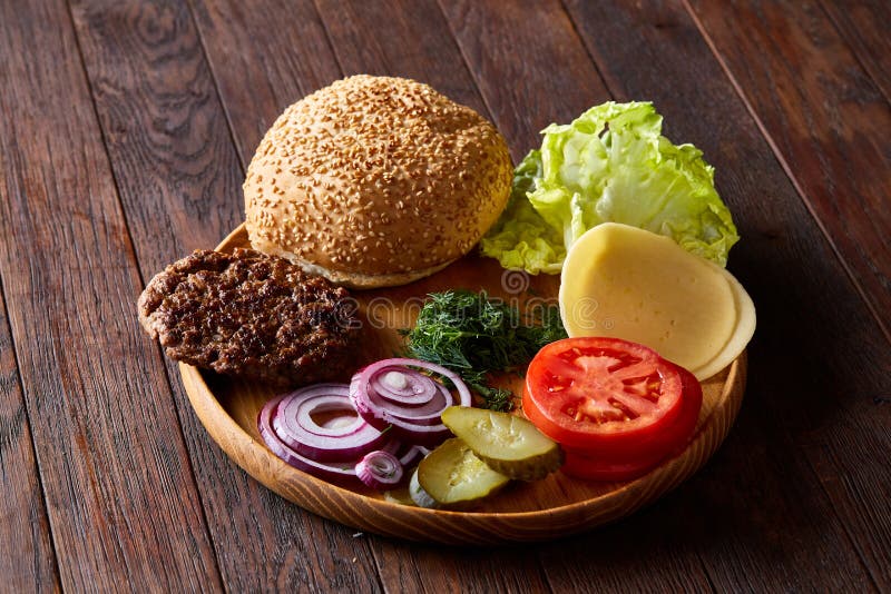 Yummy hamburgeringrediënten op houten plaat, close-up, hoogste mening, selectieve nadruk artistiek worden georganiseerd die stock fotografie Yummy hamburgeringrediënten op houten plaat, close-up, hoogste mening, selectieve nadruk artistiek worden georganiseerd die stock fotografie