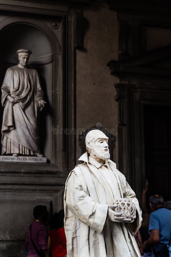 Living statue monk. Statue Cosimo di Giovanniin Piazzale in the Niches of the Uffizi Colonnade in the background. Florence. Italy. Living statue monk. Statue Cosimo di Giovanniin Piazzale in the Niches of the Uffizi Colonnade in the background. Florence. Italy