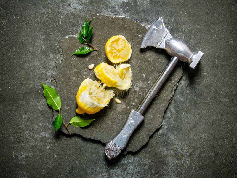Yxan med citronen och sidor på en sten står royaltyfria foton Yxan med citronen och sidor på en sten står royaltyfria foton