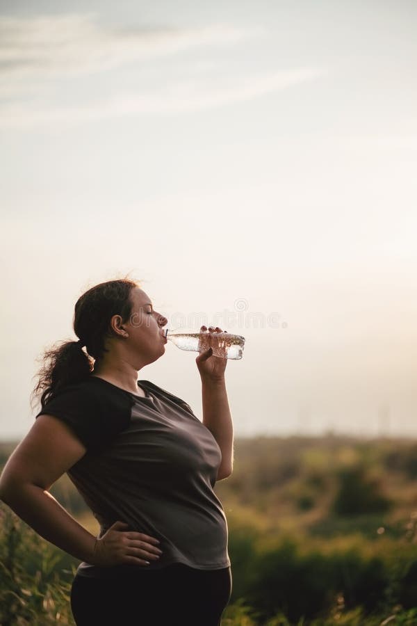Z nadwag? kobiety woda pitna po treningu fotografia royalty free Z nadwag? kobiety woda pitna po treningu fotografia royalty free