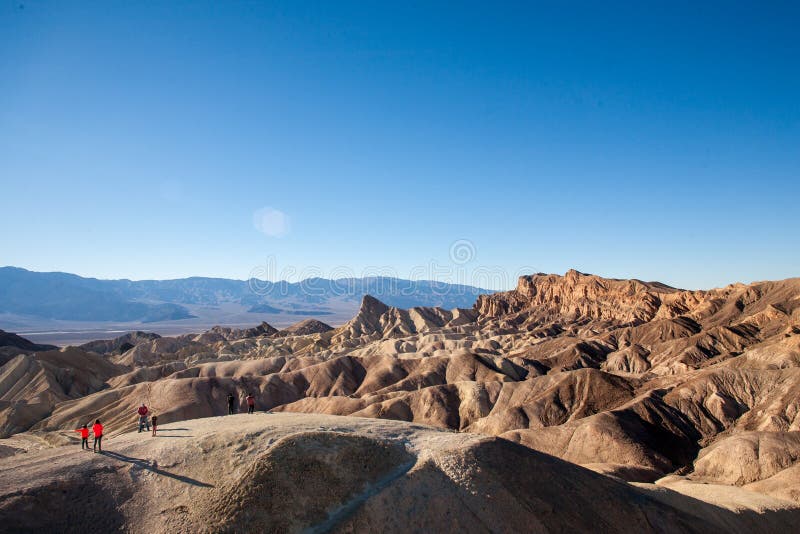 Folded mountains, zabriskie point is a unique geological curiosity in the Death Valley California. Some tiny people are exploring the area. Folded mountains, zabriskie point is a unique geological curiosity in the Death Valley California. Some tiny people are exploring the area