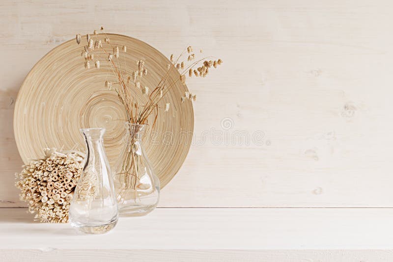 Zacht huisdecor van glasvaas met aartjes en houten plaat op witte houten achtergrond